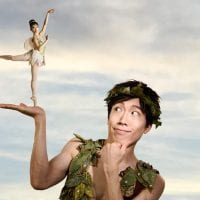 young man dressed as Peter Pan holding a small fairy in their hand